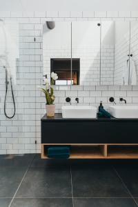 a bathroom with two sinks and a mirror at Mews Cottages in Gisborne