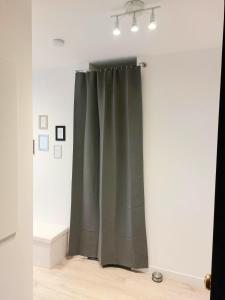 a green curtain in a room with a white wall at Cosy Home 1, Cergy Le Haut, 6 personnes, 3 min gare, 30 min Paris, parking privé in Cergy