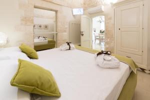 - une chambre avec 2 lits et des serviettes dans l'établissement Trullo Melograno - Dimore nel Tempo, à Alberobello