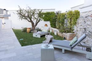 - une terrasse avec un canapé et une table dans la cour dans l'établissement Trullo Melograno - Dimore nel Tempo, à Alberobello