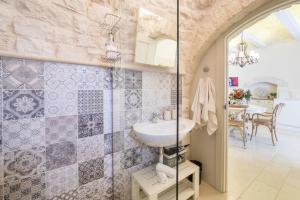 La salle de bains est pourvue d'un lavabo et d'une table. dans l'établissement Trullo Melograno - Dimore nel Tempo, à Alberobello