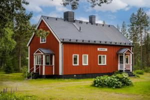 a red house with a gray roof at Fjällnära stuga med längdspår & sjö i närheten in Vemhån