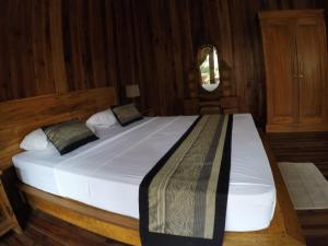 Gili Smile Bungalow في غيلي تراوانغان: سرير أبيض كبير في غرفة خشبية