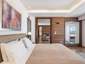 a bedroom with a large bed and a living room at Minoa Palace Resort in Platanias