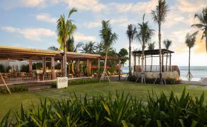 un complejo con cenador y palmeras en Amarta Beach Retreat by Nakula, en Tabanan
