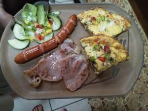 a plate of food with ham and sausage and a salad at Khokha Moya Guesthouse in Ermelo