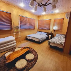 een kamer met 2 bedden, een tafel en ramen bij Leehakjang guesthouse in Mokpo