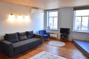 a living room with a couch and a tv at Uliha Apartamenti in Liepāja