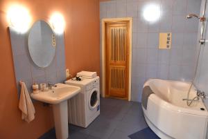 a bathroom with a sink and a washing machine at Uliha Apartamenti in Liepāja +35 photos