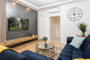 a living room with a blue couch and a table at Design 1BDR Loft near Kvaternik Square in Zagreb