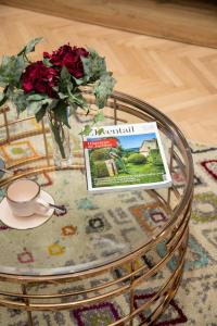 a coffee table with a magazine and a vase of roses at Design 1BDR Loft near Kvaternik Square in Zagreb