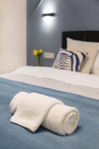 a white towel is laying on a bed at Design 1BDR Loft near Kvaternik Square in Zagreb
