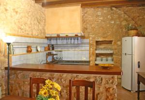 a kitchen with a counter and a white refrigerator at Son Fumat in Es Llombards