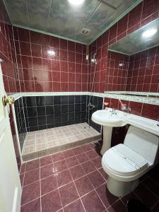 een rood betegelde badkamer met een toilet en een wastafel bij Ekonomy Hotel in Mokpo