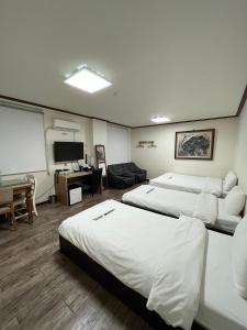 a hotel room with two beds and a flat screen tv at Ekonomy Hotel in Mokpo