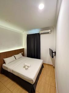 a bedroom with a bed with a white pillow on it at Gemilang Hotel in Kota Kinabalu