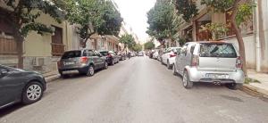 een straat met auto's aan de kant van de weg bij Athens' Secret Jewel in Athene