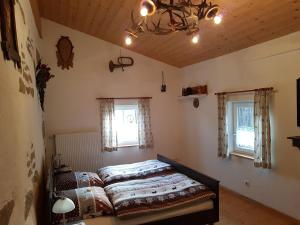 1 dormitorio con 1 cama y 2 ventanas en Ferienhaus Rachelblick, en Kirchberg