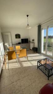 a living room with a glass table and chairs at Maison 4 personnes dans village Cœur du perche avec toutes commodités Mini 2jours in Condé-sur-Huisne