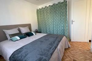 a bedroom with a large bed with a green wall at Maison 4 personnes dans village Cœur du perche avec toutes commodités Min 2 nuits in Condé-sur-Huisne