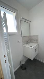 a white bathroom with a sink and a window at Maison 4 personnes dans village Cœur du perche avec toutes commodités Min 2 nuits in Condé-sur-Huisne