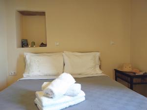 - une chambre avec un lit et des serviettes dans l'établissement Pure Nature House, à Andros
