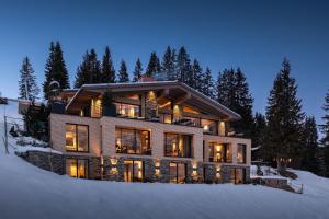 a large house in the snow at night at LE CHALET - Luxury Hideaway in Oberlech