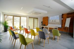 a waiting room with chairs and a table and a screen at Hotel Adalbert Szent Tamás ház in Esztergom
