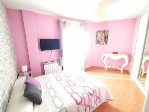 1 dormitorio con cama blanca y pared rosa en CASA DEL HUEVO, 8 a 16 pers, RIOJA ALAVESA, a 15km de Logroño y Laguardia, en Viñaspre