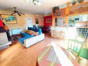 sala de estar con sofá azul y cocina en CASA DEL HUEVO, 8 a 16 pers, RIOJA ALAVESA, a 15km de Logroño y Laguardia, en Viñaspre