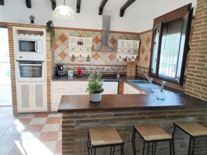 una cocina con una gran isla con taburetes. en Relax, vistas, barbacoa y piscina, junto a Ronda en Arriate