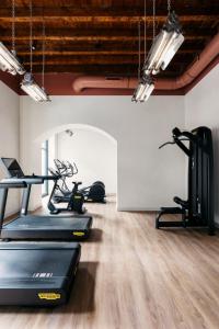 un gimnasio con cinta de correr y equipamiento para hacer ejercicio en una habitación en Aethos Milan, en Milán