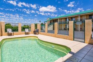 a swimming pool in front of a building at Soldiers Motel in Mudgee