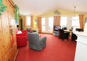 - un salon doté de moquette rouge et d'un sol rouge dans l'établissement Seepark Sellin - Haus Baabe - FeWo 432, à Sellin