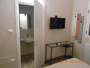 a bathroom with a sink and a television on the wall at Le Stanze in Bologna +8 photos