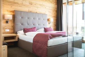 1 dormitorio con 1 cama grande y mesa de cristal en Hotel Der Heinrichshof en Lagundo