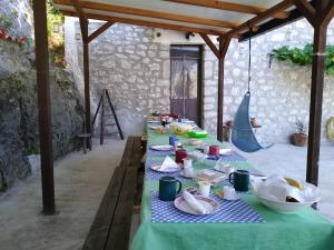 einen Tisch mit Teller mit Lebensmitteln auf einem blauen Tischtuch in der Unterkunft B&B La Casa Vecchia in Gallo