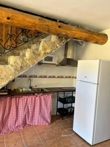 eine Küche mit einem weißen Kühlschrank und einem Tisch in der Unterkunft Casas rurales La Trufa Madre Casa 3 in Vega del Cadorno