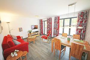 a living room with a red couch and a table at Haus Aurum - Appartment Prora Nova in Binz