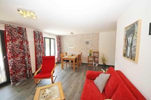ein Wohnzimmer mit einem roten Sofa und einem Tisch in der Unterkunft Haus Aurum - Appartment Prora Nova in Binz