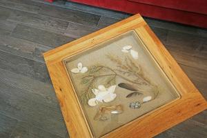 a wooden frame with a picture of flowers and butterflies at Haus Aurum - Appartment Prora Nova in Binz