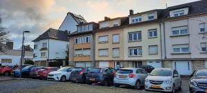 a row of cars parked in a parking lot in front of a building at Capital Flat 70m2 in Luxembourg