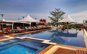 uma piscina com cadeiras e guarda-sóis num resort em Dang Derm Khaosan em Banguecoque