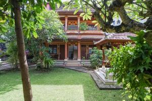 uma casa com um jardim em frente em Indopurejoy House - Komala Indah Cottages em Kuta