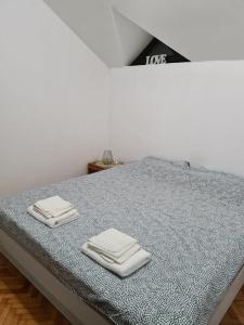 ein Bett mit zwei gefalteten Handtüchern darüber in der Unterkunft Green door 2 in Vrnjačka Banja