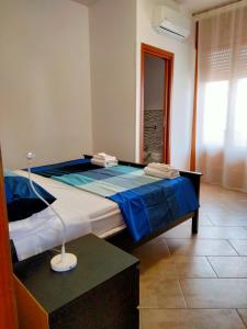 a bedroom with a large bed with blue sheets at Colori Del Salento in Cellino San Marco
