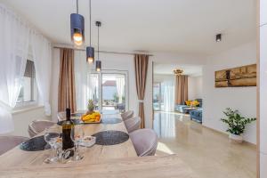 a dining room and living room with a table and chairs at Holiday house VILLA ANDRO in Pinezici