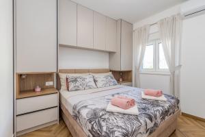 a bedroom with a bed with two pink pillows on it at Holiday house VILLA ANDRO in Pinezici +32 photos