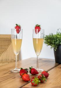 deux verres de champagne et des fraises sur une table dans l'établissement Magma Milos Studios II, à Adamas