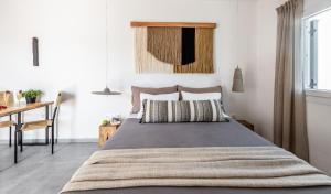 a bedroom with a bed and a table and a desk at Magma Milos Studios II in Adamas